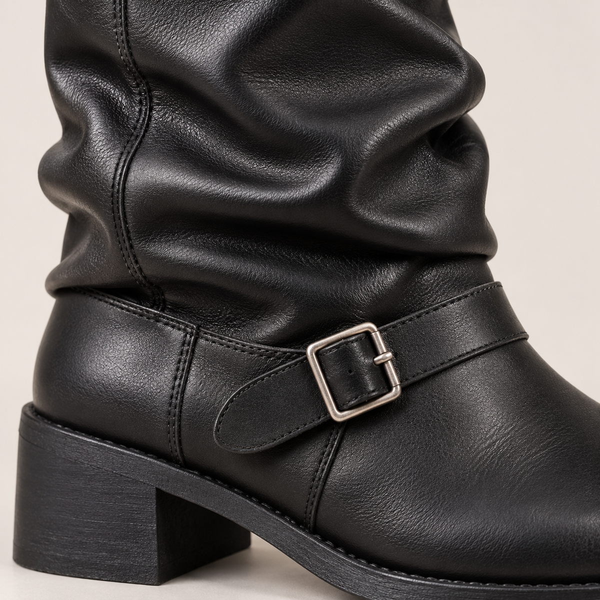 Detalle de hebilla y pliegues de bota motera negra