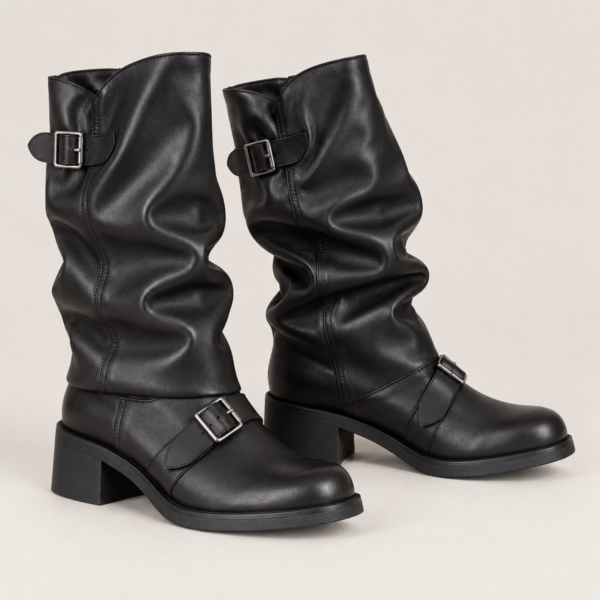 Botas moteras negras fruncidas con hebillas en estudio