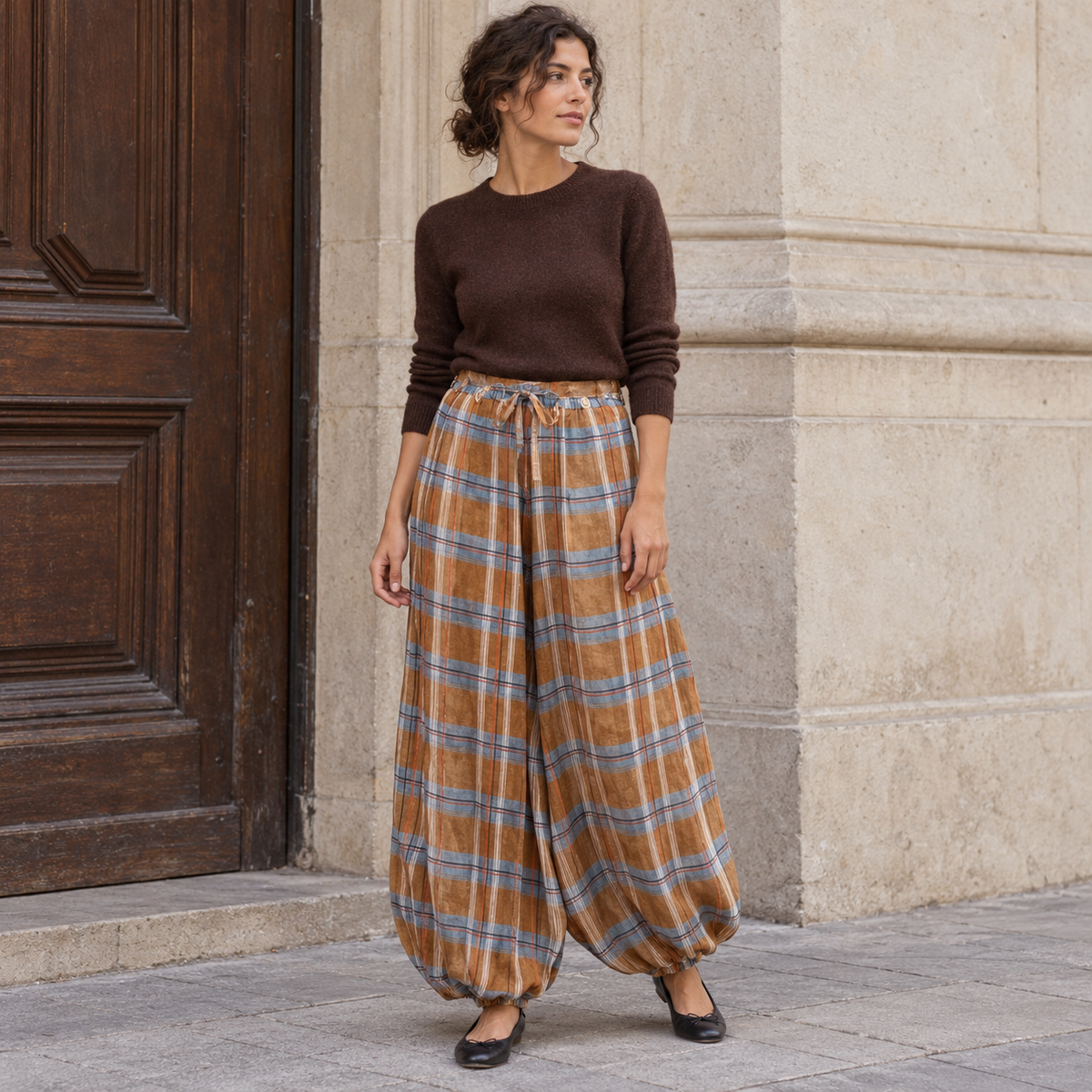 Pantalón bombacho de cuadros camel con jersey marrón en la calle