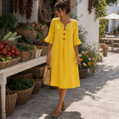 Vestido de lino amarillo con botones en mercado mediterráneo