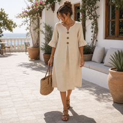 Vestido de lino beige con botones en terraza mediterránea