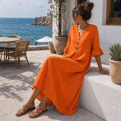 Vestido de lino naranja con botones en cafetería mediterránea
