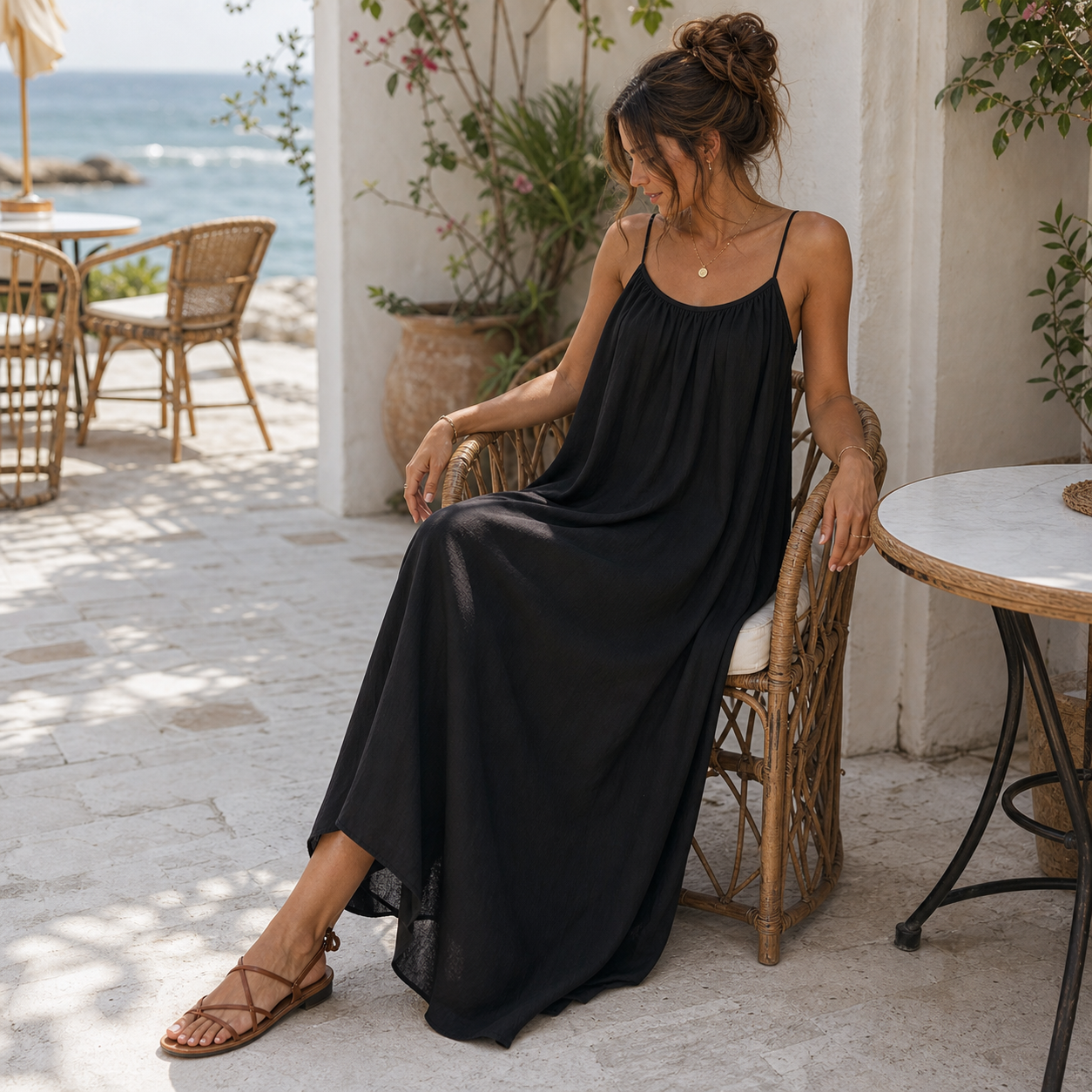 Vestido maxi negro suelto sentado en terraza mediterránea