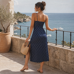 Vestido midi azul marino de topos blancos en terraza frente al mar