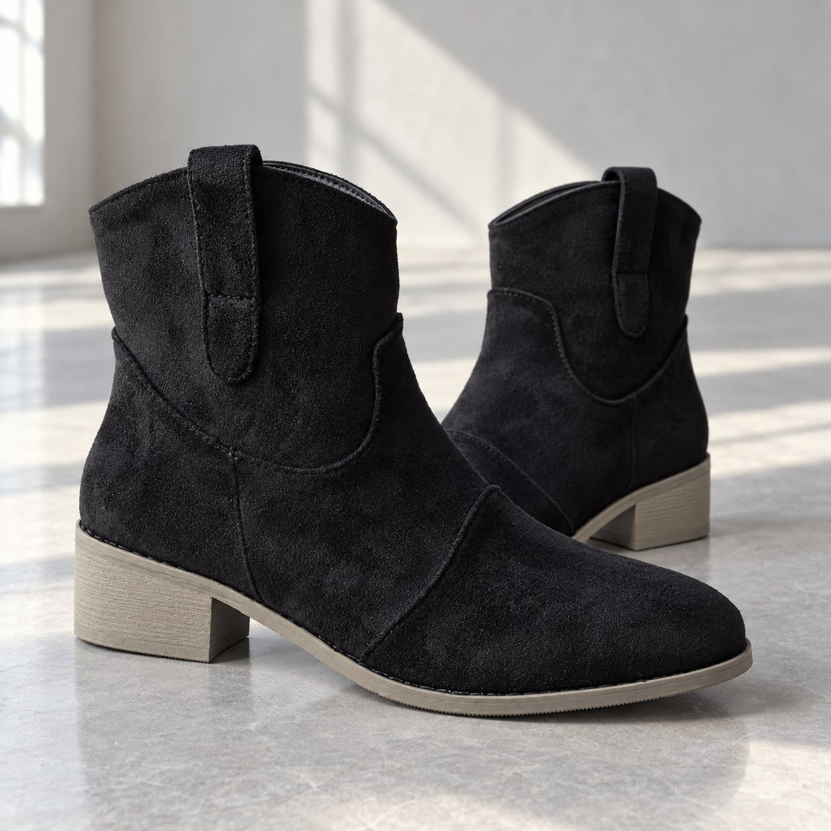 Botines cowboy negros de efecto ante en vista lateral de estudio