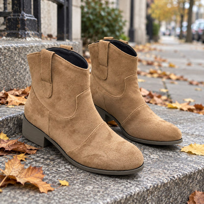 Botines cowboy camel de efecto ante sobre un escalón de piedra con hojas