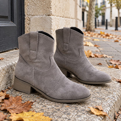 Botines cowboy grises de efecto ante junto a una entrada urbana