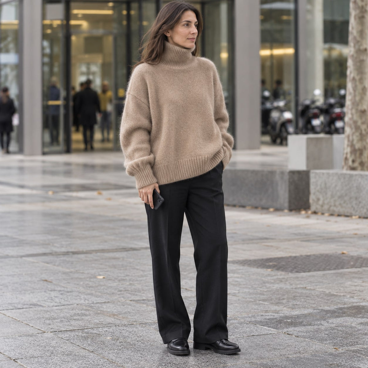 Jersey oversize de cuello alto camel en una entrada urbana de oficinas