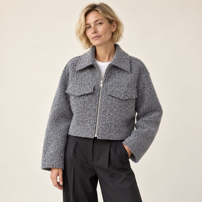 Chaqueta corta gris bouclé con cremallera en estudio