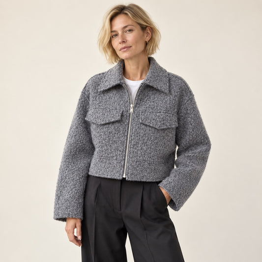 Chaqueta corta gris bouclé con cremallera en estudio