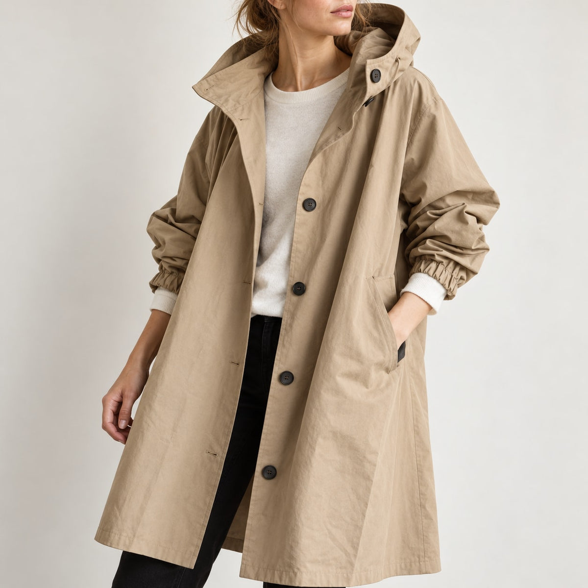 Detalle medio de la gabardina beige con capucha y botones negros