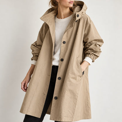 Detalle medio de la gabardina beige con capucha y botones negros
