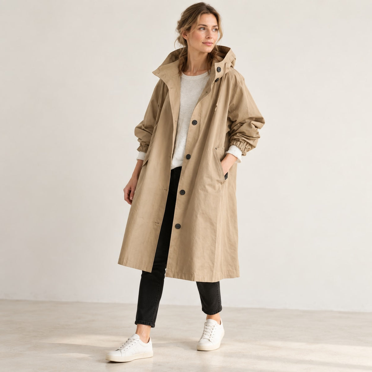 Gabardina larga beige con capucha en estudio