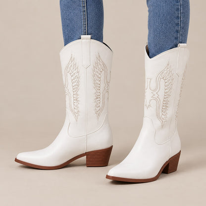 Botas cowboy blancas bordadas puestas con vaquero en estudio