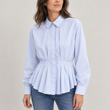 Blusa azul claro de popelín con pliegues en estudio