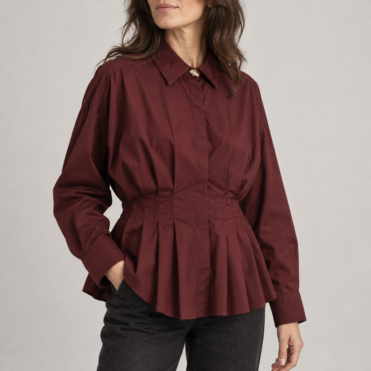 Blusa granate de popelín con pliegues en estudio