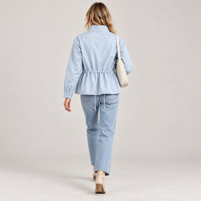 Chaqueta entretiempo azul claro de espaldas caminando, peplum y cordón