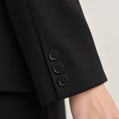 Detalle del puño del blazer corto negro con tres botones