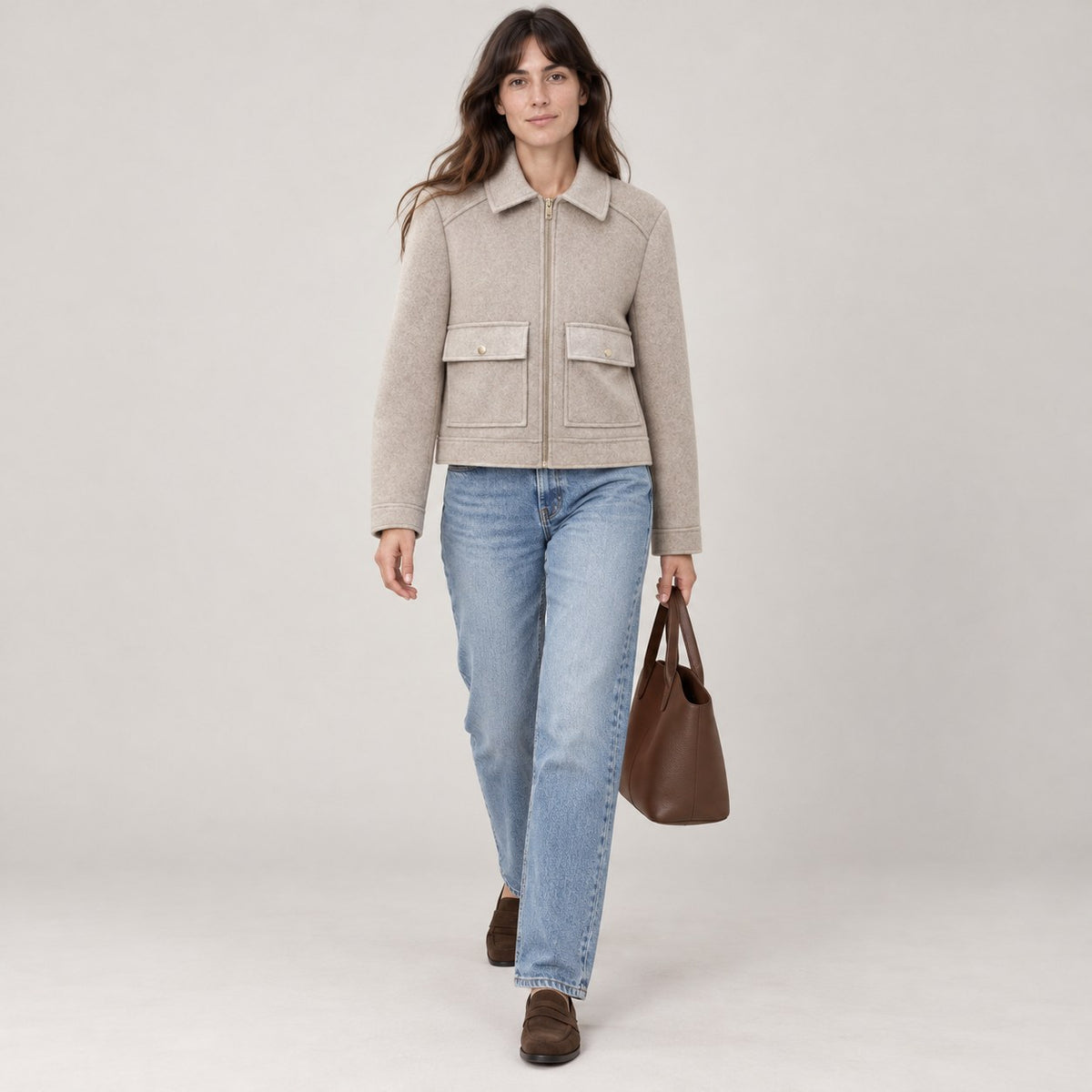 Chaquetón corto caqui caminando con bolso marrón