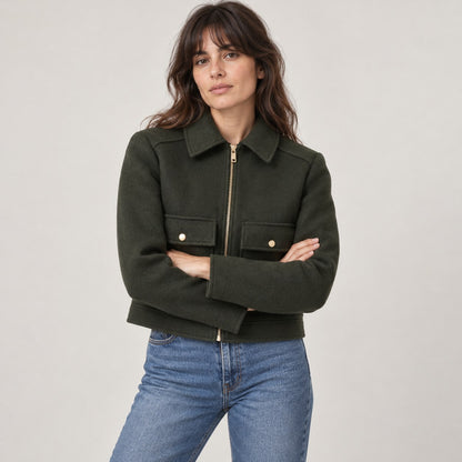 Chaquetón corto verde oscuro con los brazos cruzados
