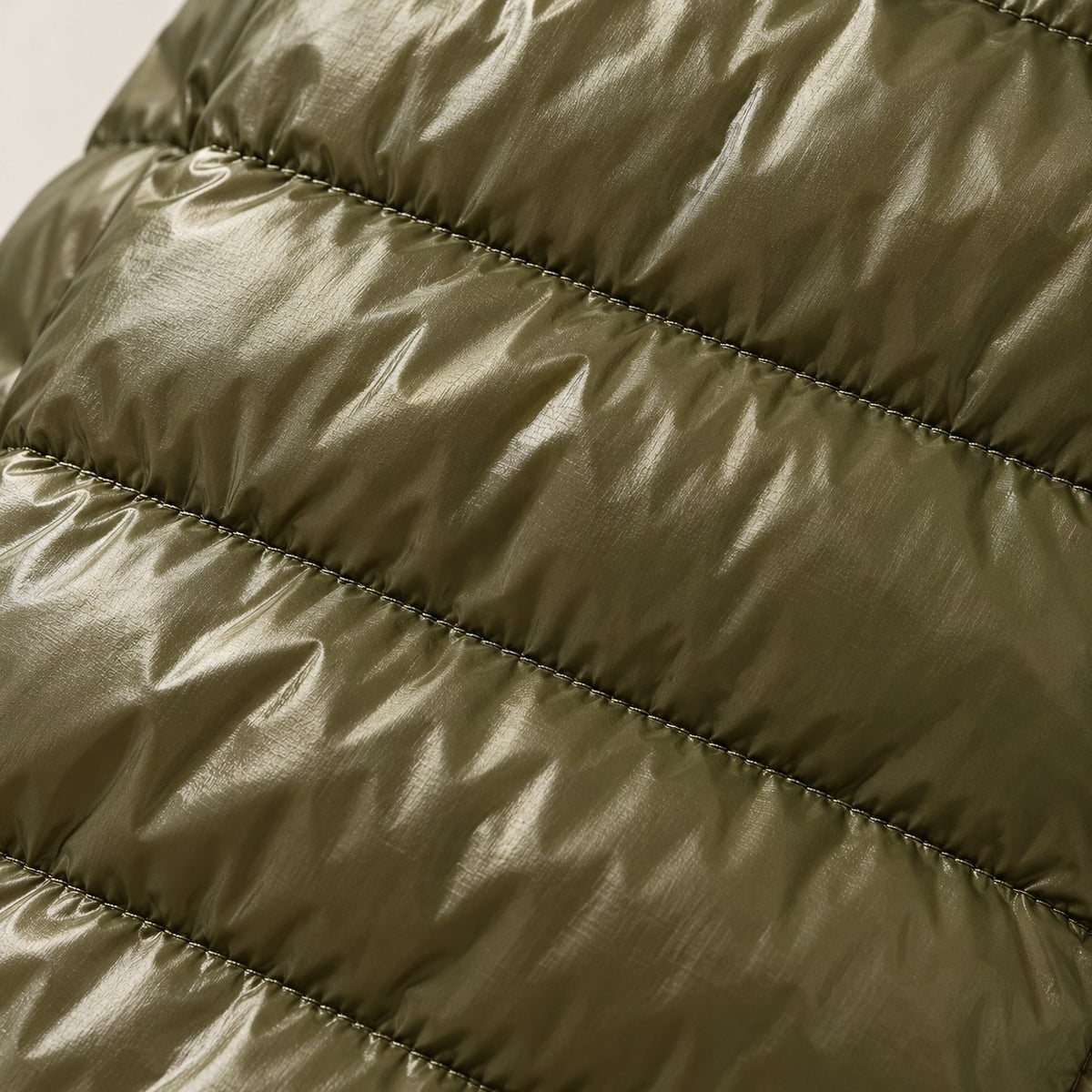 Detalle del acolchado brillante del plumón verde militar