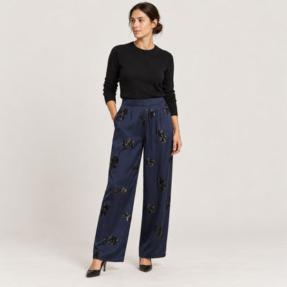 Pantalón ancho azul marino con lentejuelas y jersey negro, de cuerpo entero