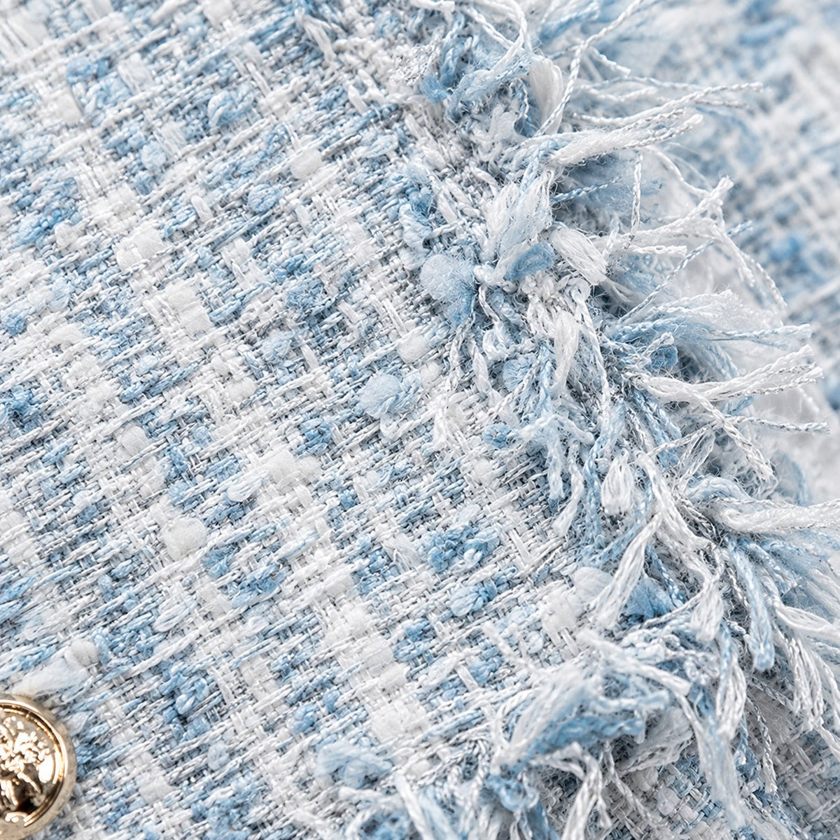 Detalle del tejido tweed azul cielo con flecos