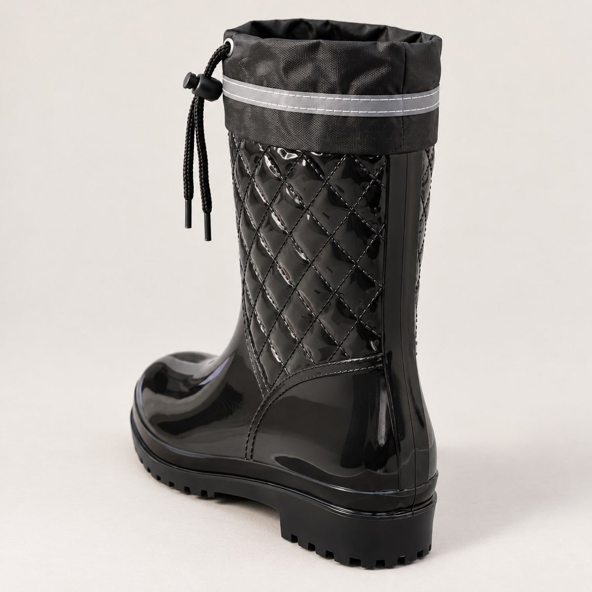 Bota de agua negra acolchada vista por detrás, con polaina de nailon y cordón
