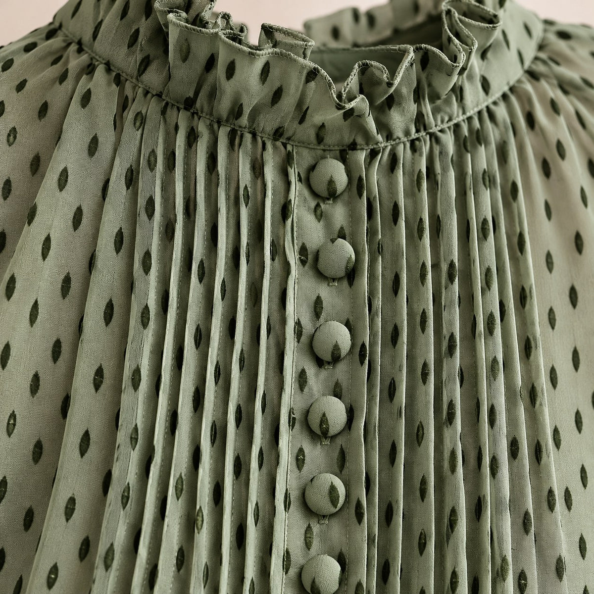 Detalle del cuello de volante, las alforzas y los botones forrados