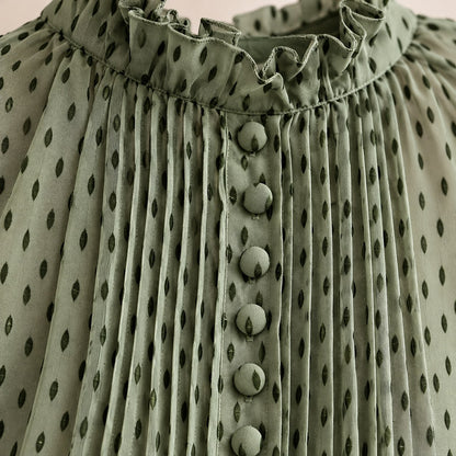 Detalle del cuello de volante, las alforzas y los botones forrados