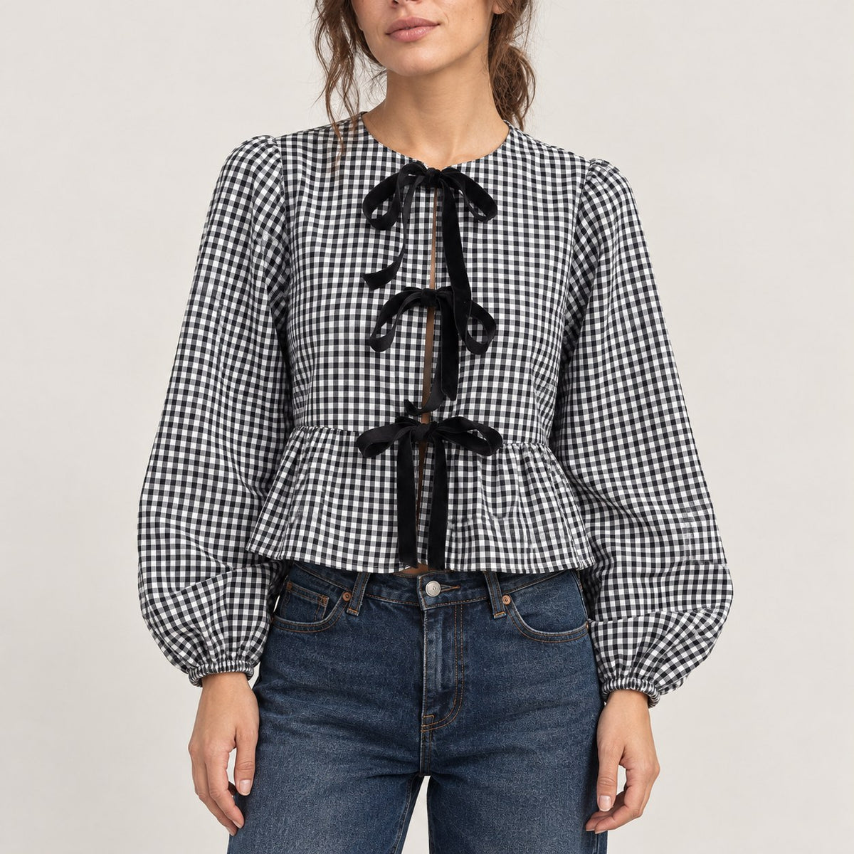 Blusa negra de cuadros vichy con tres lazos y peplum, plano medio