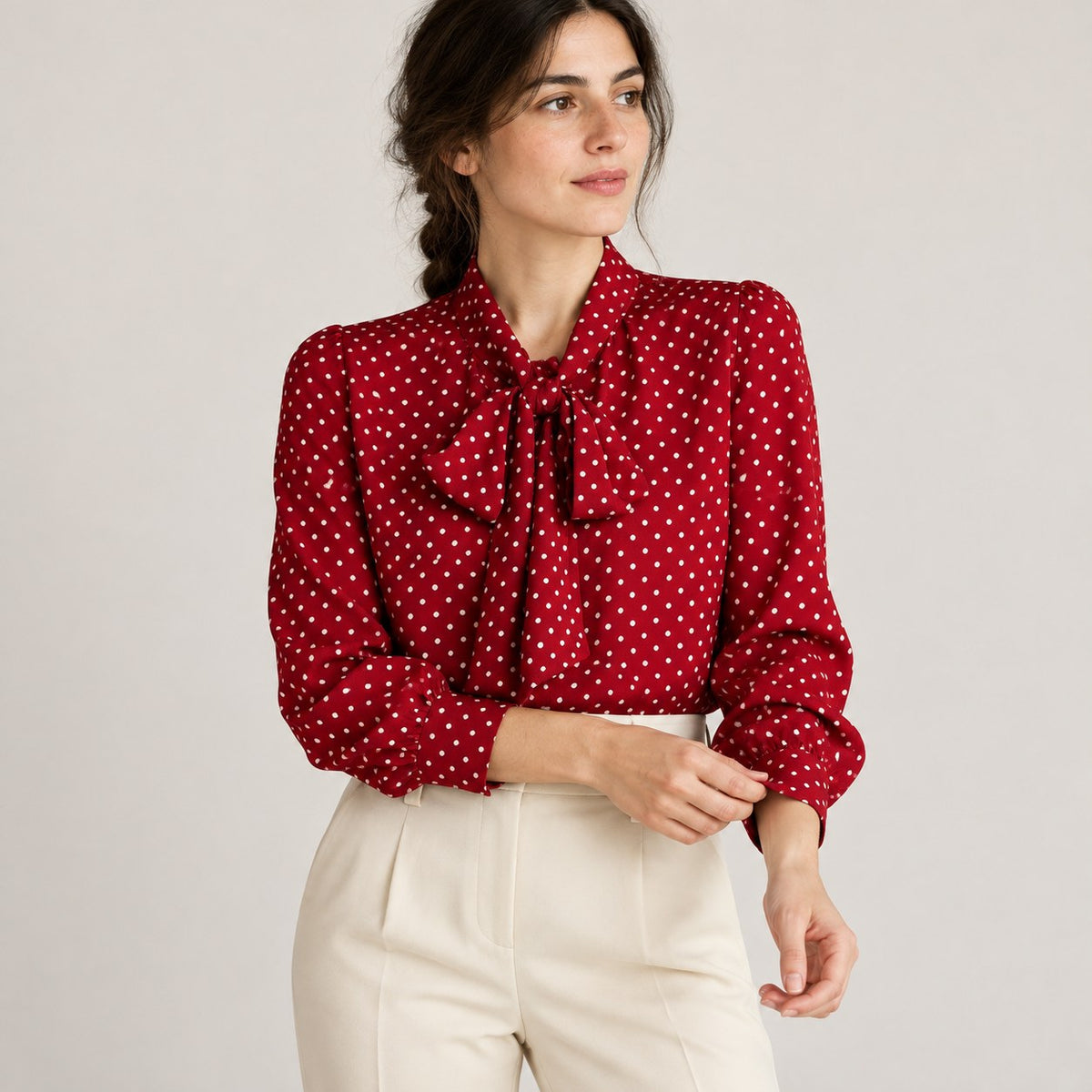 Blusa roja de lunares con lazada al cuello y pantalón crudo, plano medio