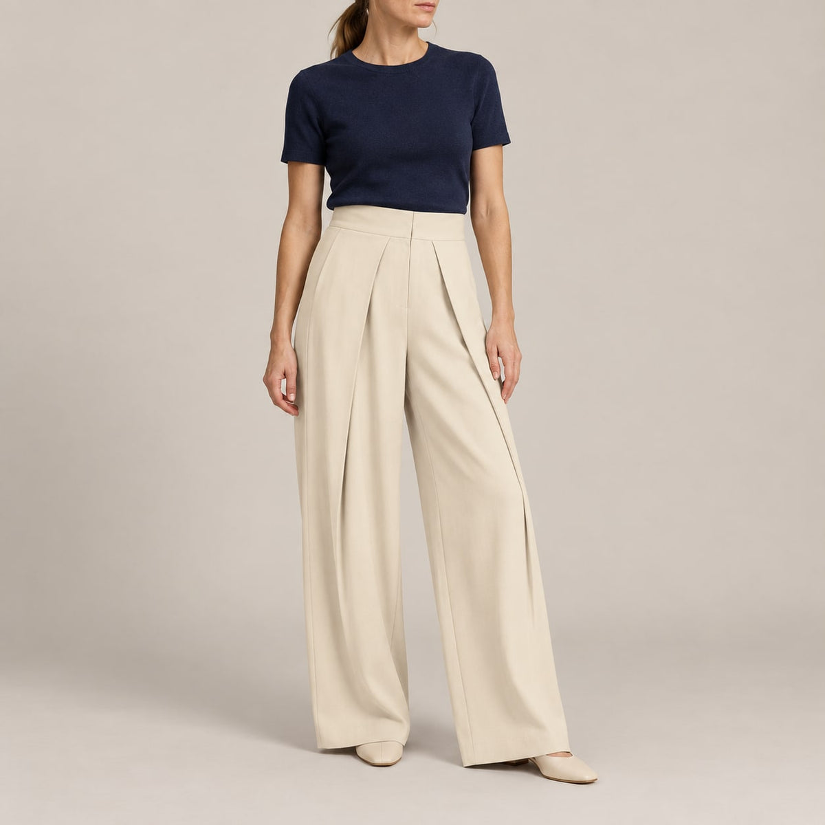Pantalón ancho plisado beige para mujer en estudio