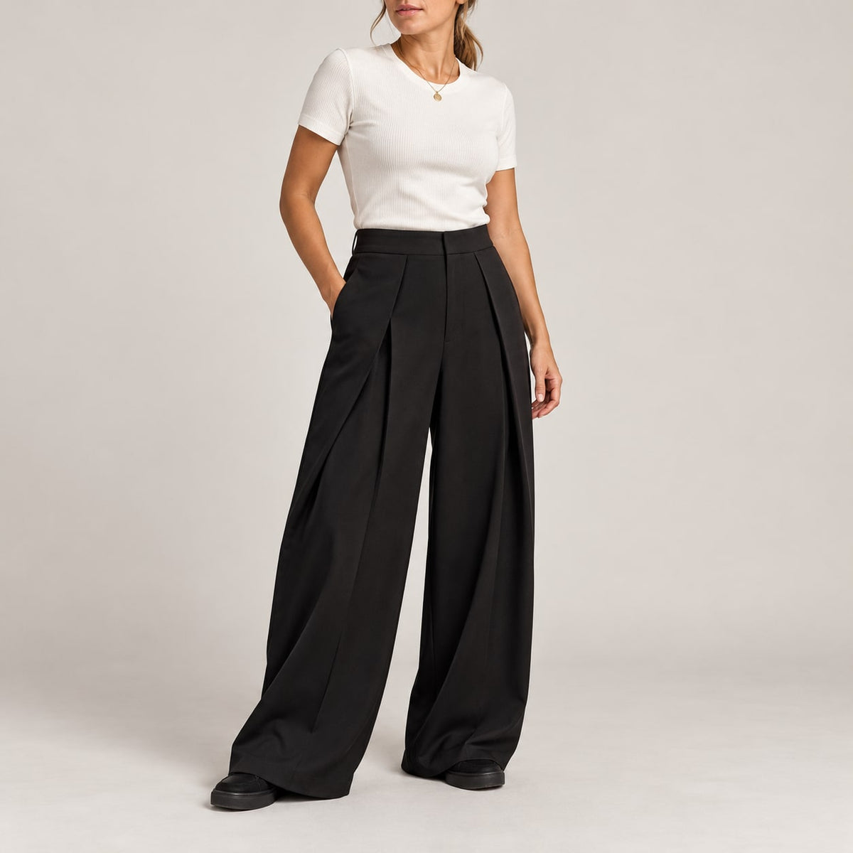 Pantalón ancho plisado negro para mujer en estudio