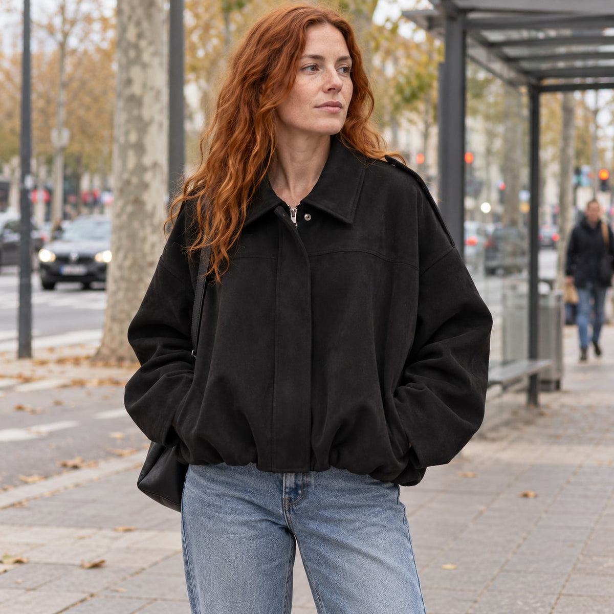 Chaqueta bomber de ante sintético negra en una avenida urbana