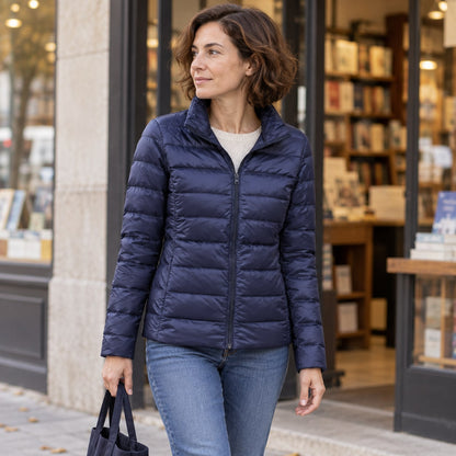 Chaqueta de plumón corta azul marino junto a una librería urbana