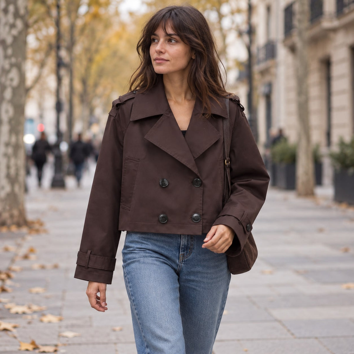 Trench corto cruzado chocolate en una avenida de otoño