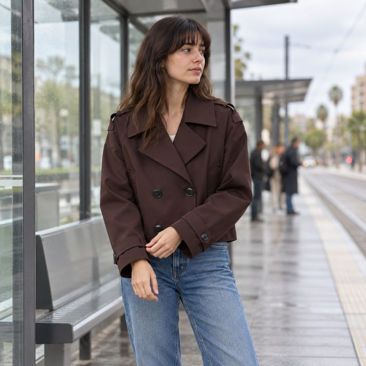 Trench corto cruzado chocolate en una parada urbana
