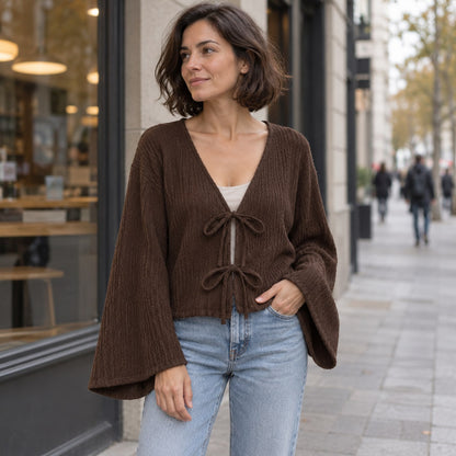 Blusa de punto café con lazada y mangas amplias en la ciudad