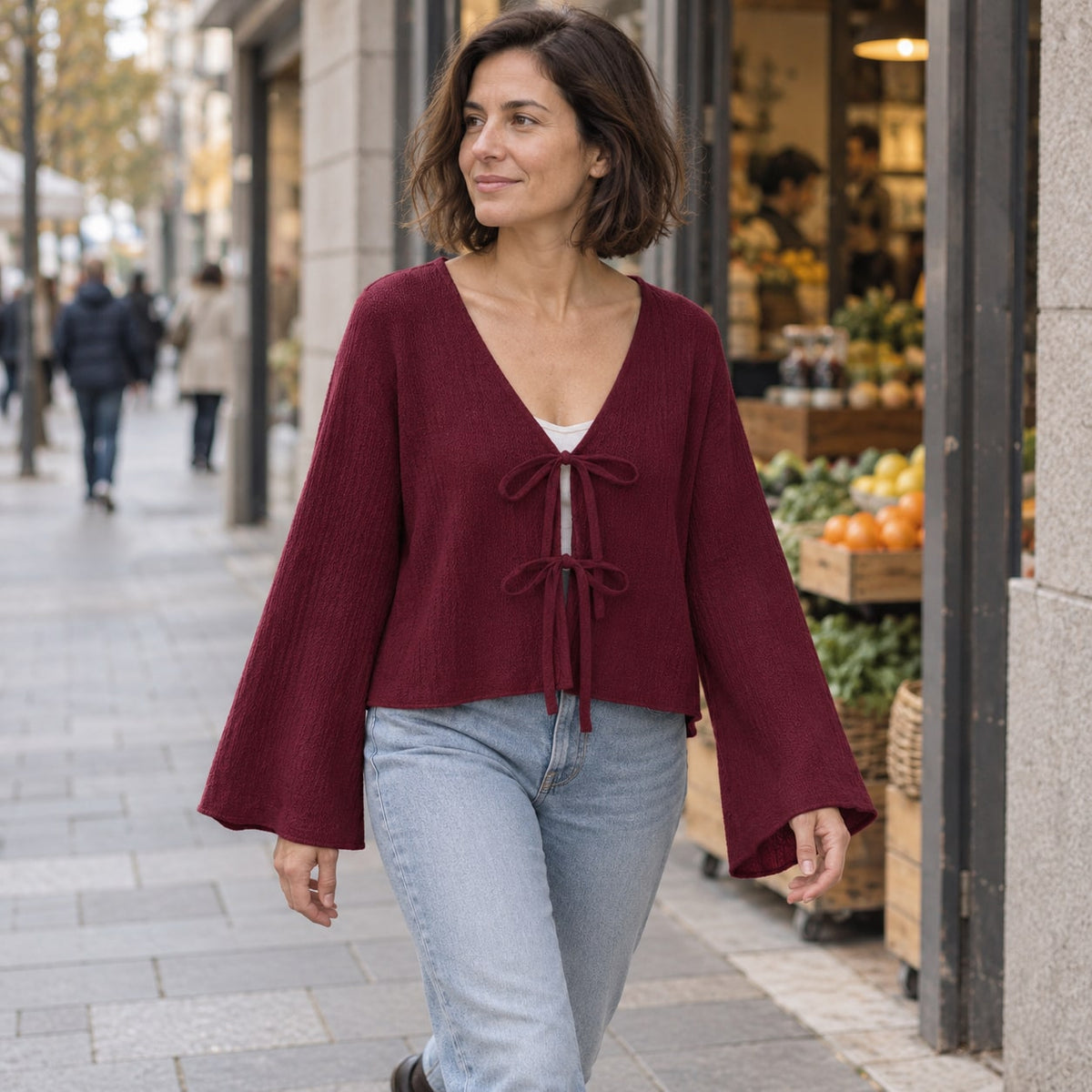 Blusa de punto burdeos con lazada en paseo urbano de otoño