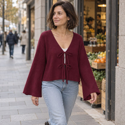 Blusa de punto burdeos con lazada en paseo urbano de otoño