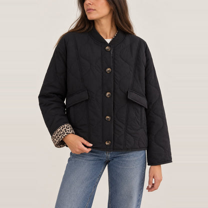 Chaqueta acolchada corta negra con botones en estudio