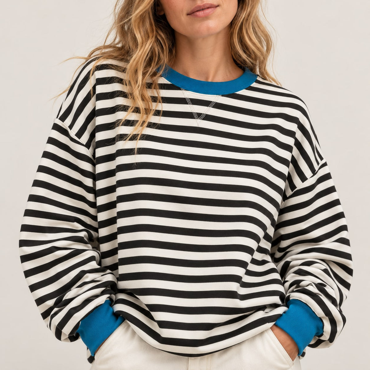 Detalle frontal del jersey oversize de rayas negro y blanco con ribetes azules