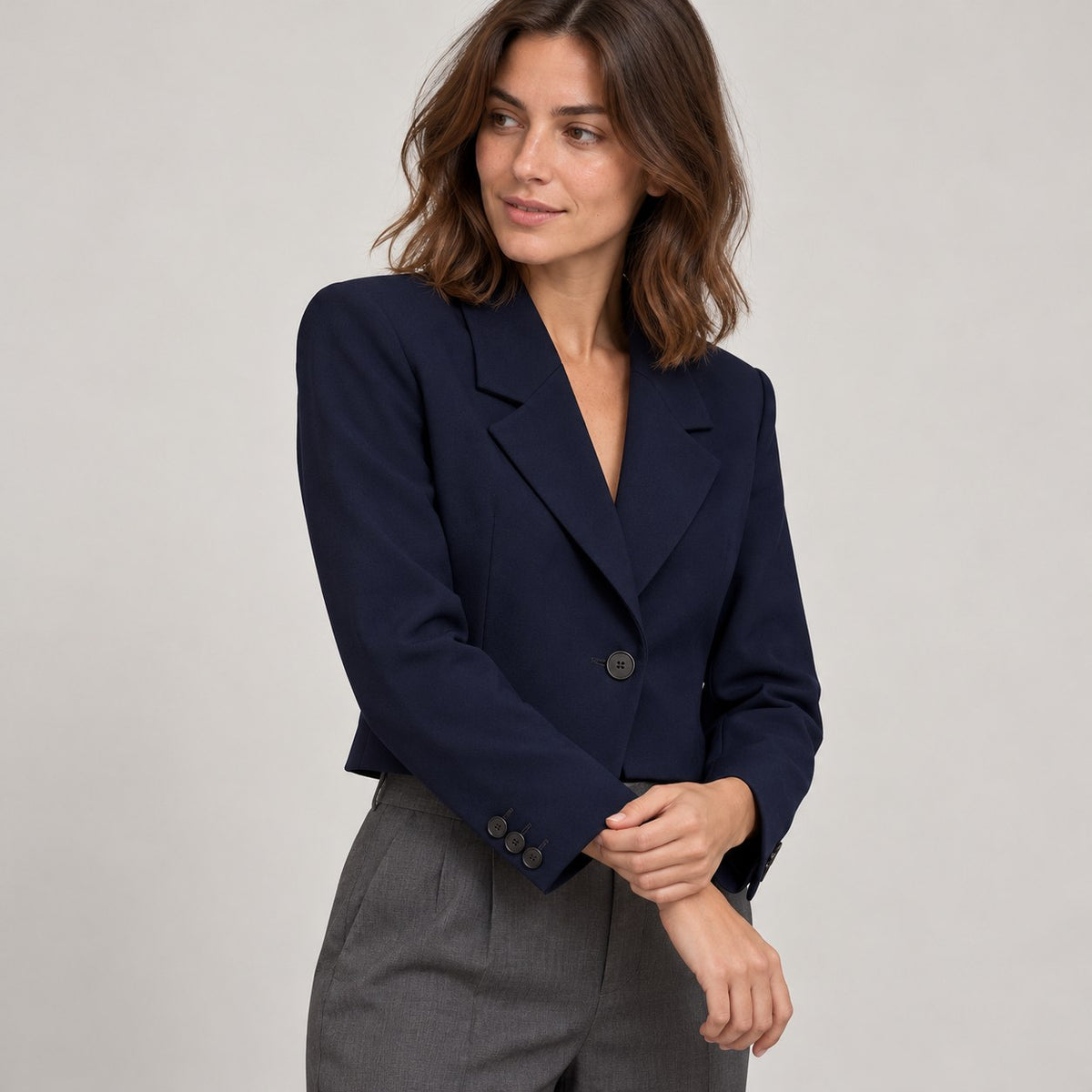 Blazer recto azul marino en estudio, detalle de los botones del puño