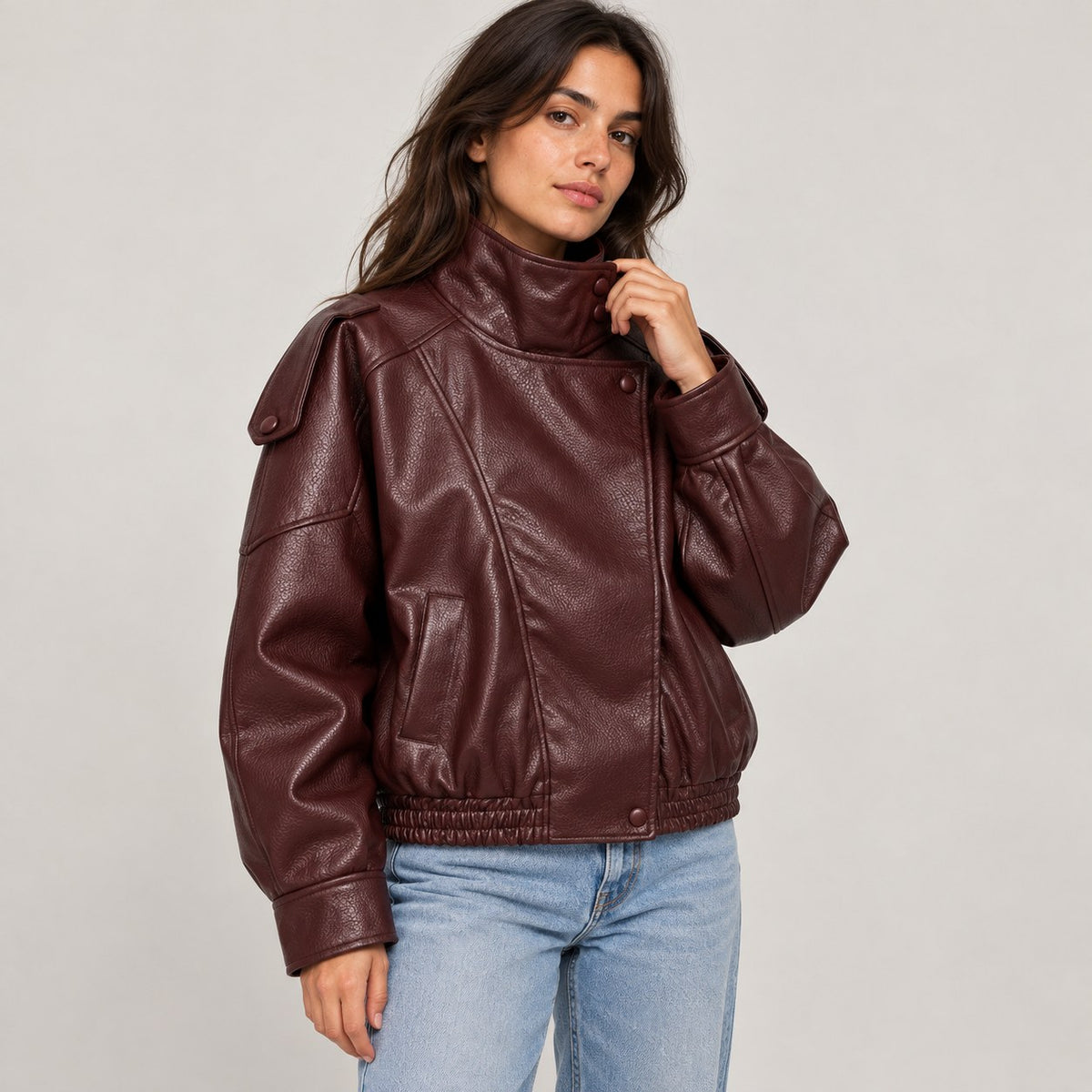 Chaqueta de piel sintética oversize burdeos en estudio, con cuello alto cruzado