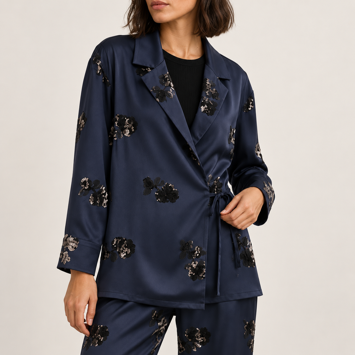 Blazer azul marino con flores de lentejuelas y lazada lateral, plano medio de estudio