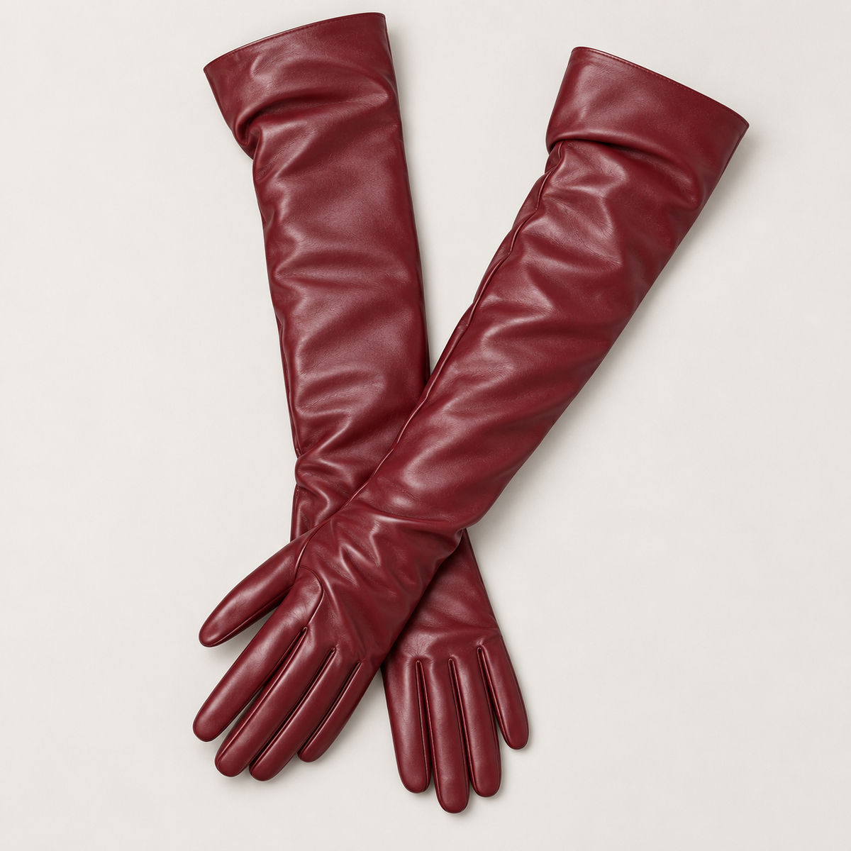 Par de guantes largos de piel burdeos en estudio