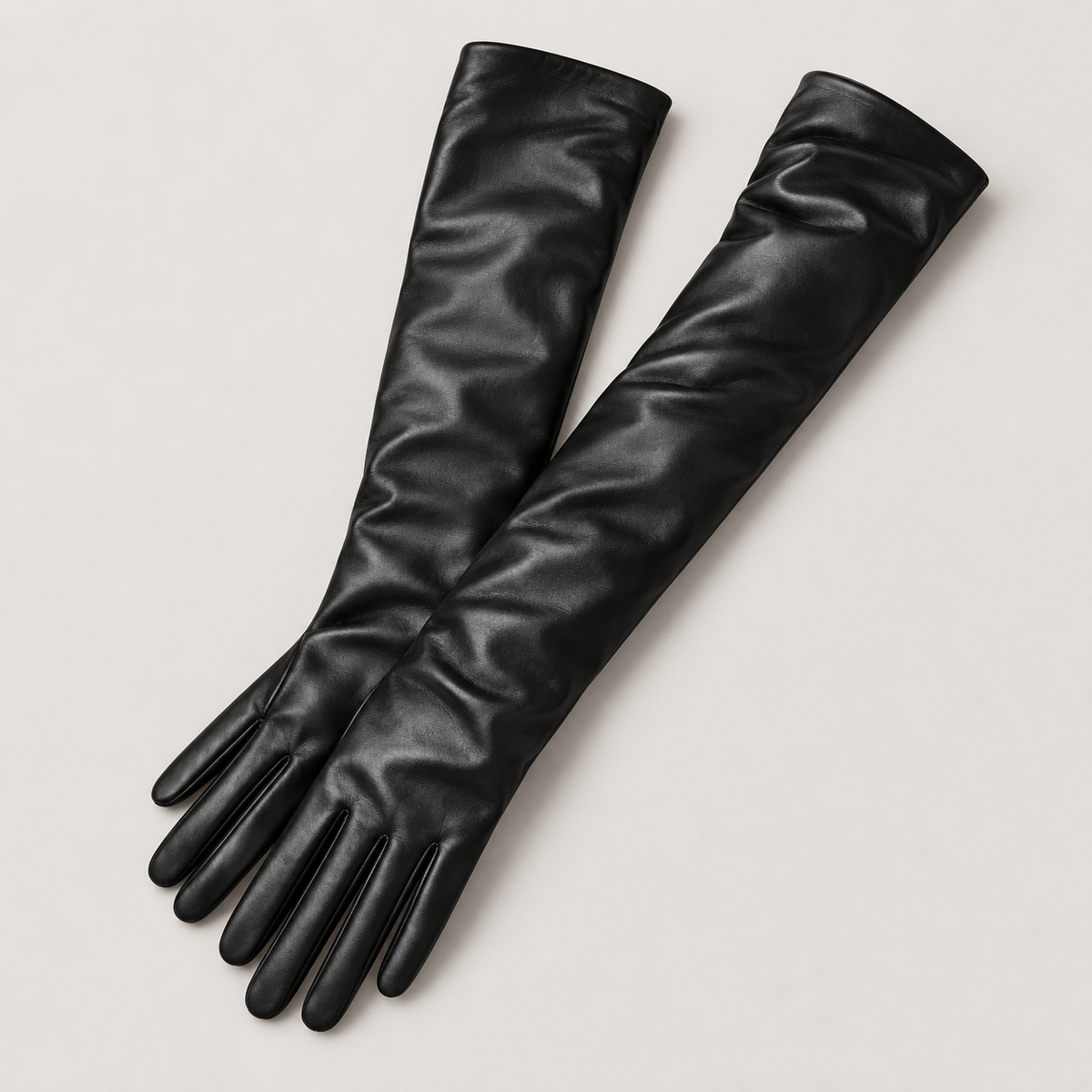 Par de guantes largos de piel negros en estudio