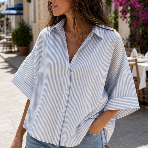 Camisa oversize de rayas finas azul y blanco en calle mediterránea