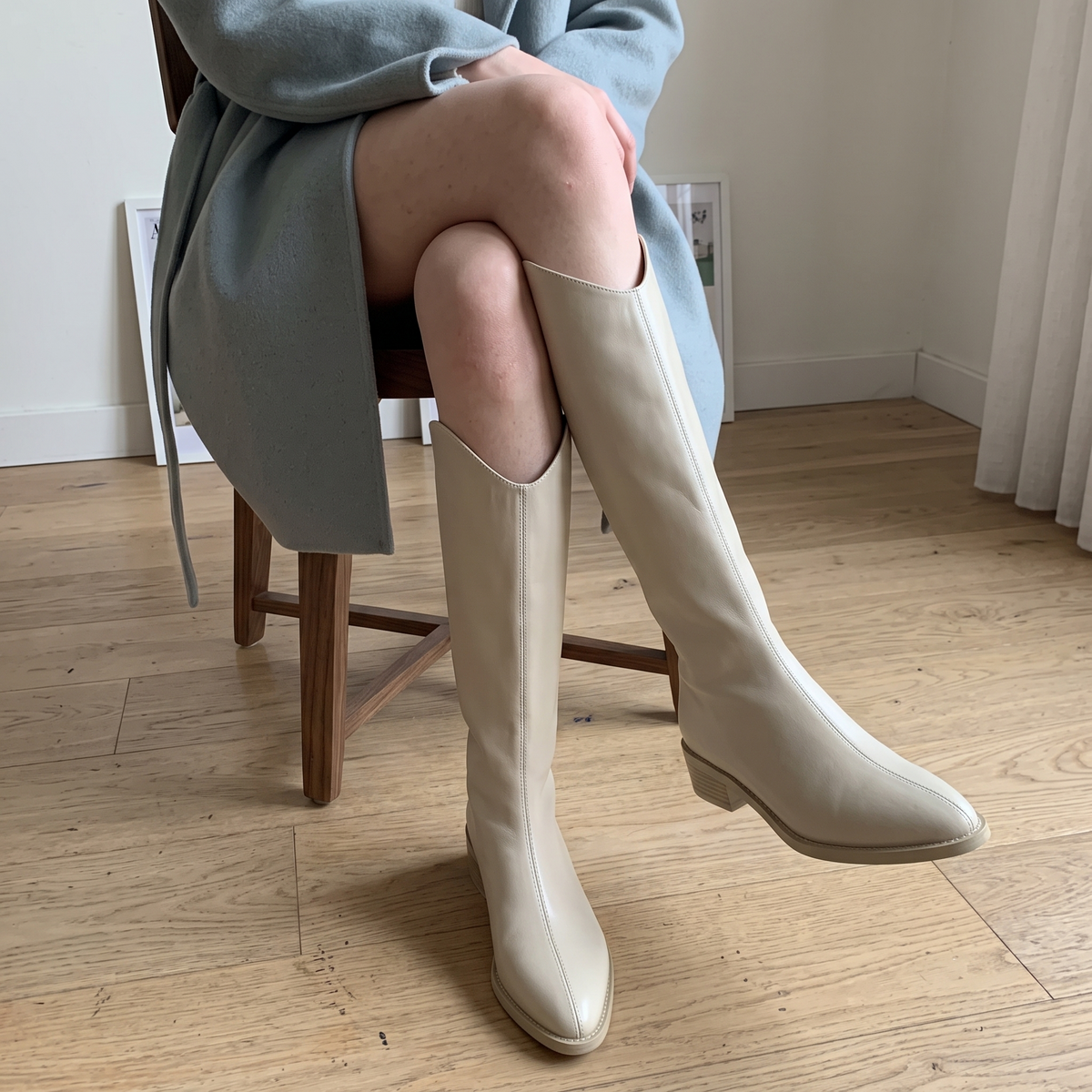 Botas altas beige con costura central puestas, foto real en casa